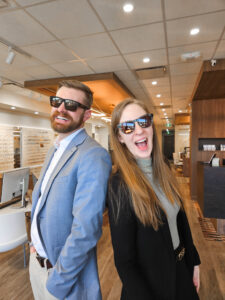 Two of our Licensed Opticians wearing new SPY Polarized Sunglasses featuring the happy lens!